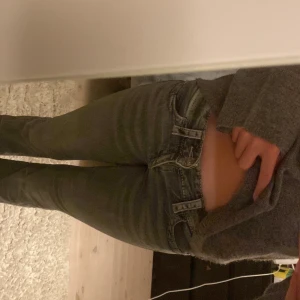 Grå bootcut jeans från Gina Tricot - Säljer ett par grå jeans från Gina Tricot i storlek 152. Jeansen har bootcut-modell, låg midja och snygga detaljerade bakfickor. Klassisk femficksdesign och tillverkade i mjukt denimtyg.