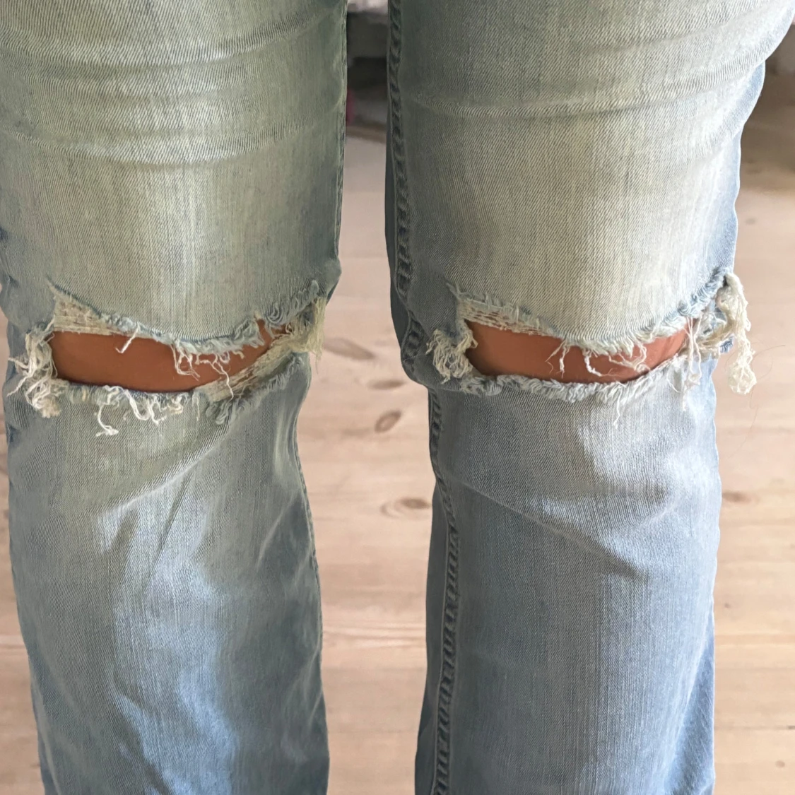 Ljusblå bootcut jeans med slitna knän - 1
