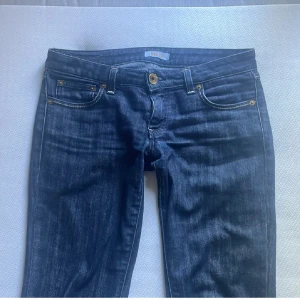 Mörkblå Lågmidjade bootcut jeans från kocca  - Snygga mörkblå jeans från Kocca med låg midja och bootcut-ben. Jeansen har slitage längst ner vid benen, jag säljer dom pga att dom är för långa och förstora i midjan på mig.Perfekta för dig som gillar en tidlös och cool look.💗 Midjemått 38cm och innebenslängd:82. Tveka inte hör av er vid frågor💗