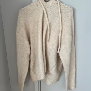 Krämvit stickad hoodie med huva - Mysig beige/vit stickad hoodie med huva perfekt till hösten. Från Gina Tricot i storlek M och är i bra skick.