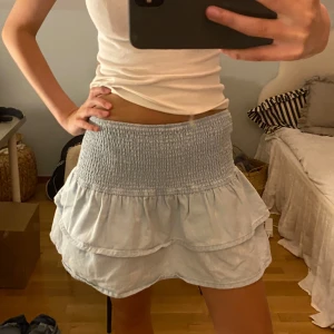 Ljusblå volangkjol med smock - Volang kjol med jeans liknande tryck! Använd fåtal gånger men har fått några bleknings fläckar i tvätten 🥲 priset går att diskuteras!