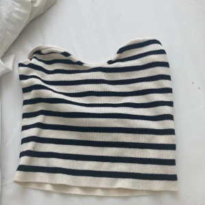 Randig tubtopp från H&M - Snygg randig tubtopp från H&M i vitt och svart. Toppen är stickad och bandeau-modell, perfekt för en chill och trendig look. Passar till både jeans och kjol för en avslappnad vibe.