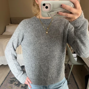 Grå stickad tröja från Zara - Mysig grå stickad tröja med rund halsringning och långa ärmar. Passar till både jeans och kjol. Enkel och stilren design som funkar till många olika outfits. 