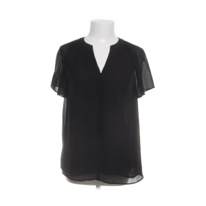 Svart blus💕💕💕 - Säljer en svart, luftig blus med korta ärmar och v-ringad hals. Blusen är tillverkad i ett tunt, transparent material som ger en elegant känsla. Perfekt att styla med både jeans och kjol.