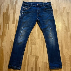 Blå jeans från Diesel - Säljer ett par blå jeansbyxor från Diesel med slitningar på framsidan! Byxorna sitter slim o e lite stretchiga. Vid frågor o funderingar så hör av er