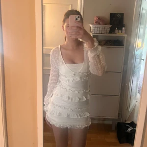 Vit volangklänning med lång ärm - Supersöt vit klänning med långärmade transparenta ärmar och flera volangdetaljer.  Perfekt för somriga tillfällen eller studentfirande. Har köpt den på Vinted men passade ej därav säljer jag den.