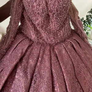 Rosa glittrig balklänning med volangdetaljer - Säljer en fantastisk rosa balklänning med glittrigt tyg och vackra volangdetaljer. Klänningen har en dramatisk, vid kjol och är täckt av skimrande paljetter som ger en lyxig känsla. Perfekt för bal eller festliga tillfällen.