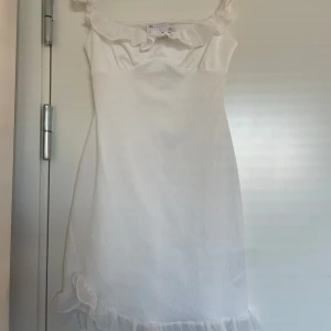 Student klänning - Supersöt vit klänning från ASOS DESIGN med volangdetaljer vid axelband och nederkant. Perfekt till studenten eller andra tillfällen i sommar💞
