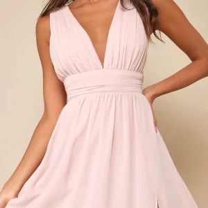 Ljusrosa balklänning med v-ringning och slits - Elegant ljusrosa balklänning med djup v-ringning och bred midjedetalj. Klänningen har plisserad överdel och en hög slits framtill för en stilren look. Perfekt för 9ans bal som kommer nu 💞Köpt för 1300kr