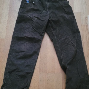 Bruna manchesterbyxor från 93 Cords Polar skate - Säljer ett par bruna manchesterbyxor,modell 93 Cords från Polar Skate. Byxorna har ett broderat motiv vid fickan och klassisk femficksdesign. Loose, baggy. Storlek 30 x 32. 