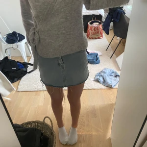 Ljusblå jeanskjol - Säljer en ljusblå jeanskjol med rå kant nertill och klassiska sömmar. Kjolen har en enkel, rak passform och är perfekt för en avslappnad stil. Passar till det mesta och är ett måste i garderoben.