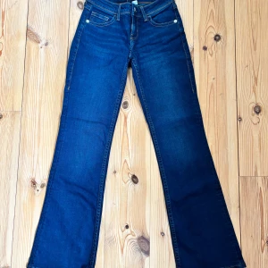 Lågmidjade Bootcut jeans - Lågmidjade mörkblåa Bootcut jeans med detaljer i storlek 34 