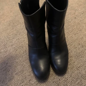 Svarta boots med klack och dragkedja - Säljer ett par svarta boots Whyred med klack och rund tå. Skorna har dragkedja på sidan.