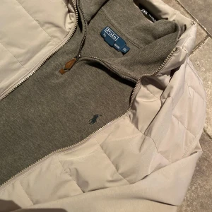Grå Quarter Zip tröja från Polo Ralph Lauren - Olivgrön äkta Ralph Lauren Quarter Zip i storlek XL. Otroligt bra skick med en liten defekt som syns på sista bilden. Färgen passar perfekt nu under våren och är utmärkt att använda med väst, Cardigans och tunnare vårjackor.  Perfekt för lager-på-lager och enkel att matcha.