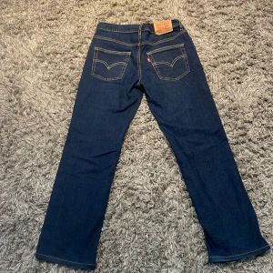 Levi's 551Z Authentic Straight jeans - Mörkblå jeans från Levi's, modell 551Z Authentic Straight. Klassisk femficksdesign med raka ben och kontrastsömmar. Ikonisk läderpatch bak i midjan och Levi's-röd etikett på bakfickan. Perfekta för dig som gillar en tidlös jeansstil.