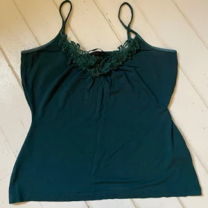 Mörkgrönt linne med spets från H&M - Insydd i midjan