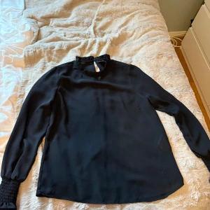 Svart blus - Svart blus som funkar till många olika tillfällen. Blusen är lite genomskinlig men inte mycket.