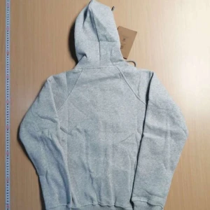 Grå hoodie från Burberry med dragkedja - Säljer en klassisk grå hoodie från Burberry i storlek M. Tröjan har dragkedja framtill, fickor och huva med Burberrys ikoniska rutiga foder. Tröjan är helt ny.