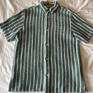 Zara, randig kortärmad skjorta - Snygg randig skjorta i grönt och vitt med korta ärmar och knappar framtill. Perfekt till sommaren! Storlek S men passar XS.