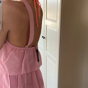 Rosa mini klänning från Boohoo - Skit Söt rosa klänning från Boohoo med volangdetaljer och öppen rygg. Klänningen har axelband som korsas i ryggen och en luftig passform!!💕💕 Säljer då den tyvärr var för liten och var mer en S/M 💕 Helt ny med lappar kvar och skickar i original förpackning 💕🥳