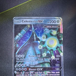 Celesteela GX Pokémonkort (inte äkta) - Säljer ett fejk Celesteela GX Pokémonkort med 200 HP. Kortet har attacker som Rocket Fall och Moon Press, samt en speciell Blaster GX-attack. Det är en Ultra Beast-kort med en futuristisk design och holografisk yta. Perfekt för samlare eller spelare som vill förstärka sin kortlek.