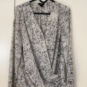 Modern blus  - Säljer den a fina svart/vita blus från Lindex!🩷 Den är nästan aldrig använd och är i samma skick som när jag köpte den!  Det finns en knapp så man kan knäppa upp blusen ännu mer om man skulle vilja göra det också!
