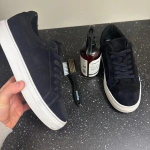 Vagabond skor  - Snygga svarta sneakers i mocka med vit sula. Skorna har snörning och en rund tå, vilket ger en klassisk och stilren look. Perfekta för en avslappnad stil. Myxket bra skick. Man får med en mocka bortse och medel så att den blir vatten tät. Färgen är ljus blå men man ser inte det så mycket på bilderna. 