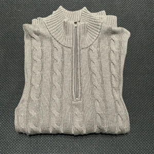 Half zip från Felix Hardy  - Säljer en stilren grå stickad tröja från Felix Hardy med dragkedja och kabelstickat mönster. Tröjan är i toppskick, inga defekter. Pris går att diskutera 