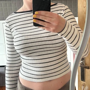 Randig ribbad topp från NA-KD - Säljer en stilren vit och svart randig ribbad topp från NA-KD. Jättefin med öppen rygg!🩷