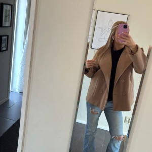 Beige kappa - Snygg beige kappa från designbysi. Perfekt inför våren. Storleken är lite större så skulle säga att den passar M också. Nästan helt oandvänd och väldigt bra skick!