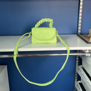 Limegrön axelväska med flätat handtag - Snygg limegrön axelväska med ett unikt flätat handtag. Väskan har en enkel design med en lång axelrem och ett praktiskt innerfack. Perfekt för att ge en färgklick till din outfit! Pris kan diskuteras! Kom privat för mer detaljer 