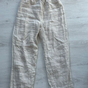 Beige linnebyxor med dragsko - Säljer dessa linnebyxor från design by si. Relativt hög midja, storlek S och i mycket fint skick. 400kr + ev frakt. 