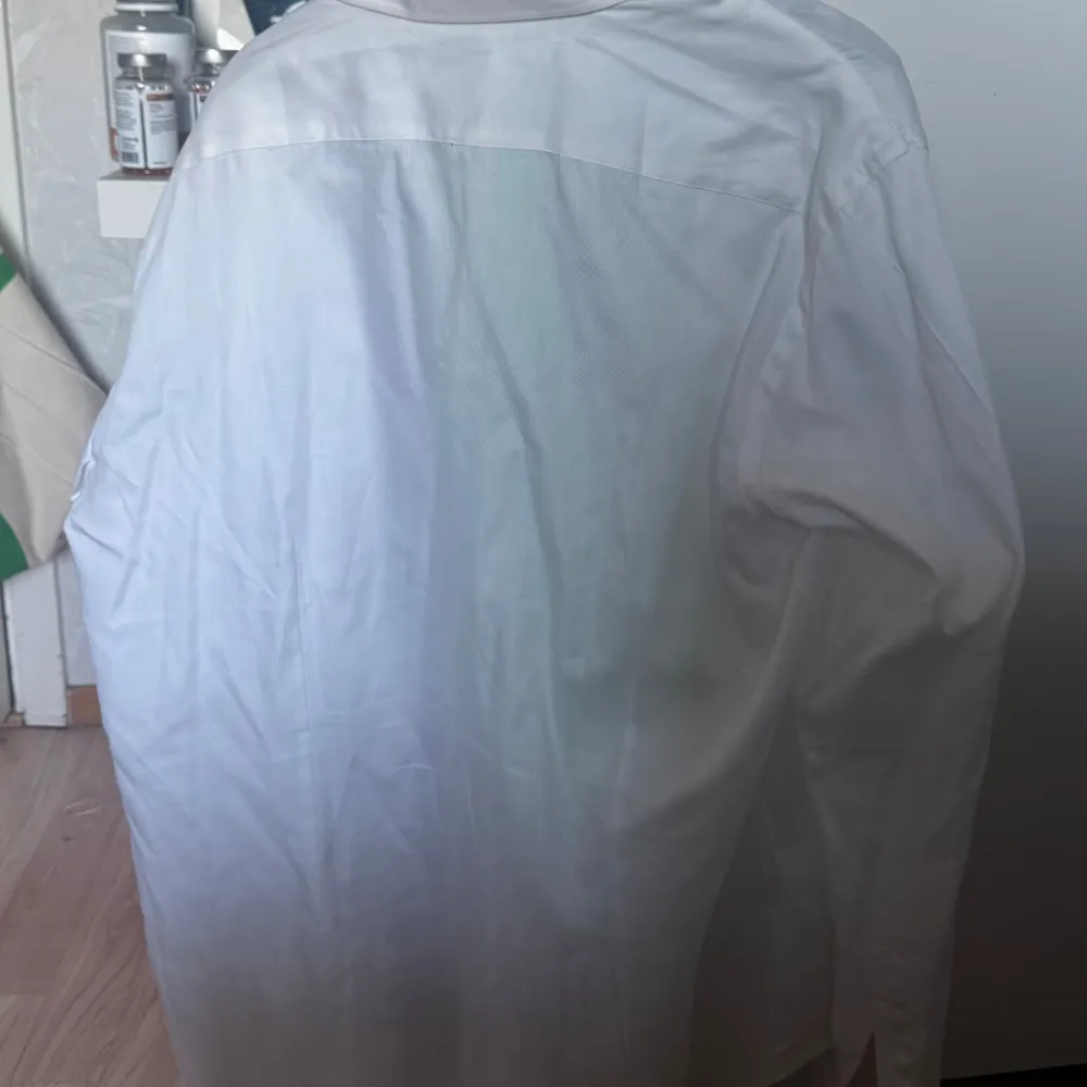 Säljer en klassisk vit skjorta från Gutteridge, tillverkad i 100% bomull. Skjortan har en stilren design med knappar framtill och en traditionell krage. Perfekt för en elegant look.. Paidat.
