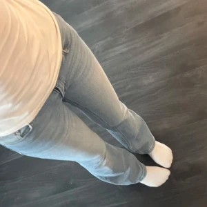 Ljusblå low waist bootcut jeans  - Säljer ett par ljusblå low waist jeans med bootcut-stil. De har en klassisk femficksdesign och är perfekta för en avslappnad look. Jeansen har en knapp och dragkedja på framsidan. 