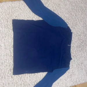Mörkblå långärmad topp - Säljer en stilren mörkblå topp/blus med långa, lite tunnare ärmar. Storleken på tröjan är S. Toppen har en enkel design som gör den lätt att matcha med olika outfits.