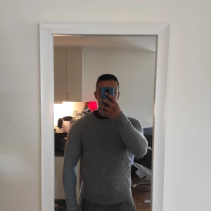 Grå tröja från Swedish Poetry - Säljer en stilren grå Kashmir tröja från Swedish Poetry. Tröjan har en klassisk design med rund hals och långa ärmar, perfekt för en avslappnad look.