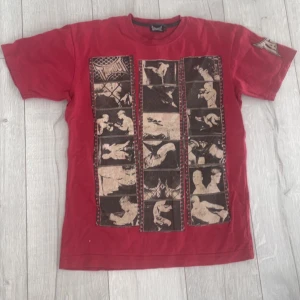 Röd t-shirt från Tapout - Säljer en cool röd t-shirt från Tapout med ett unikt tryck på framsidan. T-shirten har korta ärmar och ett stort Tapout-logotyp på baksidan. Perfekt för dig som gillar en sportig stil!