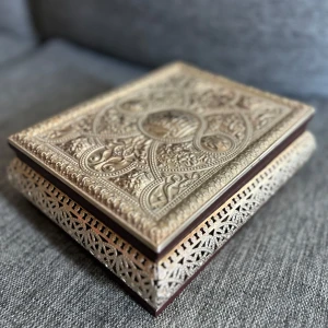 Orientalisk låda - Säljer en vacker bokformad ask med  mönster i silver och trä. Asken har en elegant design med detaljerade ornament på locket och sidorna, perfekt för att förvara småsaker eller som en dekorativ detalj i hemmet. 