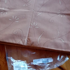 Beige tyg med blommönster 5 meters bunt  - Säljer ett beige tyg med ett elegant blommönster. Tyget är förpackat i plast och har en mjuk och stilren design som passar perfekt för olika syprojekt. Perfekt för att skapa gardiner, kuddar eller andra heminredningsdetaljer.