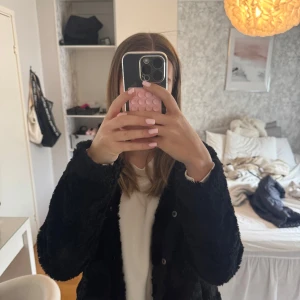 Svart pälsjacka från Vero Moda - Säljer en snygg svart pälsjacka från Vero Moda. Jackan har en mjuk och fluffig yta med knappar framtill. Perfekt för att hålla sig varm och stilren under kyliga dagar.❄️💕