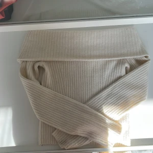 Beige ribbad offshoulder tröja från H&M - Säljer en stilren beige ribbad offshoulder tröja från H&M. Perfekt för en trendig look med långa ärmar och mjukt material. Passar utmärkt till både jeans och kjol. Skicka ett meddelande vid intresse!