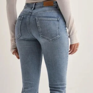 Blå bootcut jeans - Snygga blå bootcut jeans med hög midja. Perfekta för en avslappnad stil med en klassisk touch. De har en bekväm passform och är tillverkade i ett mjukt denimtyg.