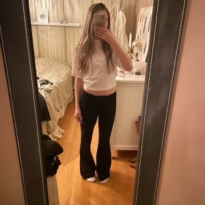 Svarta kostymbyxor - Snygga svarta bootcut kostymbyxor med låg midja. Byxorna är sparsamt använda och köpta för 500 kr, men tyvärr är de lite upptrampade nere kanten, annars fint skick!