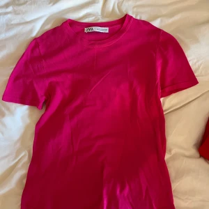 Rosa t-shirt från Zara - Säljer en snygg rosa t-shirt från Zara. Den är kortärmad. Perfekt för en färgglad vardagslook.