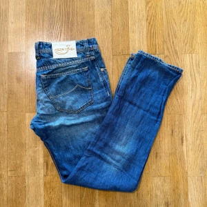 Jacob Cohën blå jeans Type 622 - Snygga blå jeans från Jacob Cohën, modell Type 622. Klassisk femficksdesign med kontrastsömmar och knappgylf. Jeansen har en tvättad look med ljusare partier och detaljerad brodyr på bakfickan samt patch i vitt med logga bak.