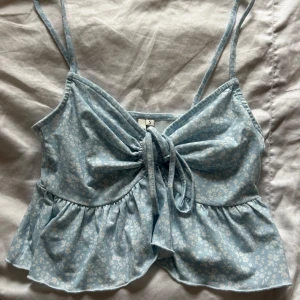 Blommig topp från NLY Trend - Supersöt ljusblå topp från NLY Trend med vita små blommor 🌸 Är använd men inga skavanker 🫶🏻
