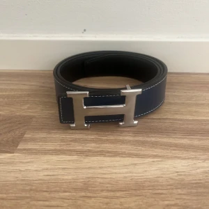 H bälte svart. 115cm  - Här har jag ett snyggt Herrmes bälte i storlek 115cm. Det är mörkblått, och har aldrig använts då det ej passade mig. Är öppen för förhandling av pris. För fler frågor,bilder,funderingar eller info, så är det bara att höra av sig så hör jag av mig så fort som möjligt! ☺️/ JonteSell