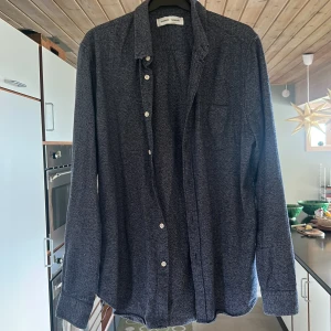 Mörkblå/vit skjorta/overshirt från Samsøe Samsøe - Snygg mörkblå tjockare skjorta från Samsøe Samsøe i modellen Liam BA. Skjortan har klassisk krage, bröstficka och vita knappar framtill. Materialet är mjukt och har en melerad look som ger en avslappnad vibe. Perfekt till jeans eller chinos. 100% bomull.