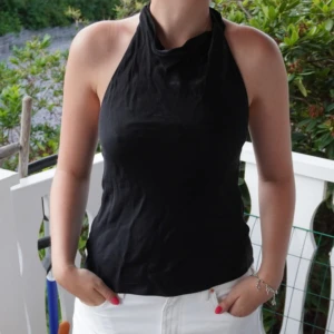 Topp - Säljer den här super fina svarta toppen från Gina tricot! På bilden är den lite skrynklig men det går att stryka! Öppen i ryggen och man knyter den i nacken! Skriv för flera bilder eller frågor💞