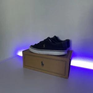 Mörk blå Ralph Lauren Strl 39! - Mörkblå Ralph Lauren skor! Skorna är i matrialet är canvas.Efter som att dem är i canvas så har dem bleknat lite pågrund av att dem tål inte vatten bra för det är de canvas tyg.Dem är perfekta för dig som har strl 37/39,5 dem är små i storleken så om du har under 39 är dessa skor perfekta för dig.Skriv vid frågor 😊Pris kan diskuteras.Dem är lite sönder där bak där det står polo kan skicka bild i dm.